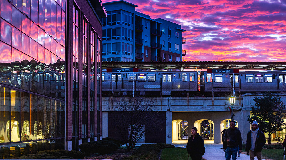 Loyola CTA campus scene lit in a pink sunset behind Damen Student Center